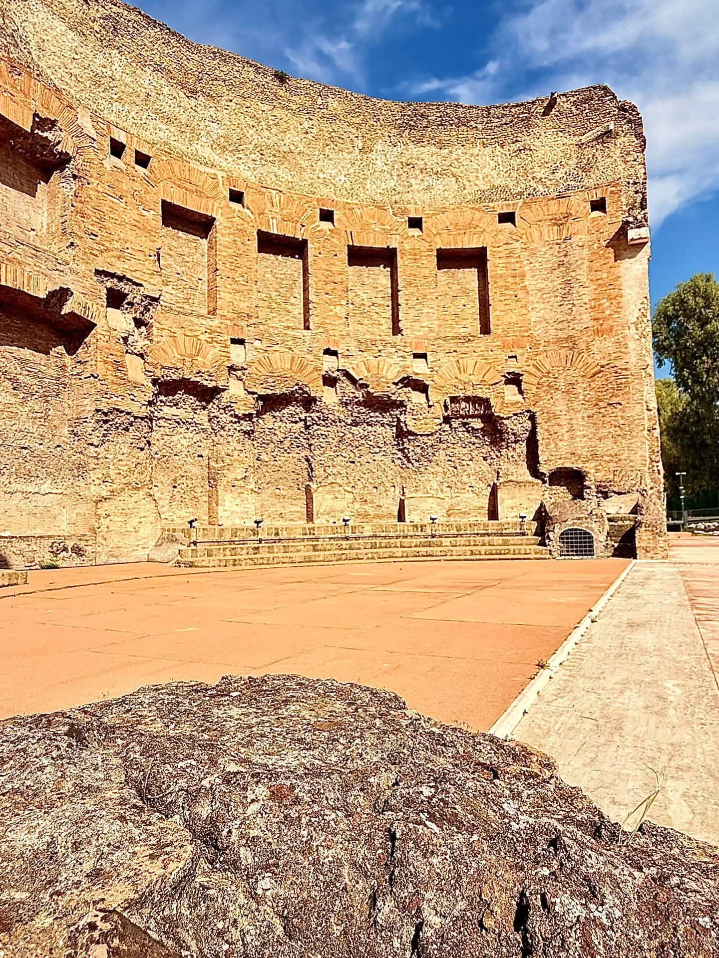 Curved brick exedra and paved archaeological area at the Baths of Trajan